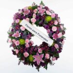 Corona de flores morada, verde y rosa para enviar a tanatorios de madrid y toledo con cinta de condolencias
